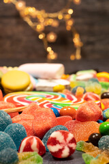 dark grey cement table with white bricks, jelly beans, marshmallows, marshmallows, candies, hearts, lollipops, leaving a space for photo text vertically.