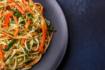 Fresh salad of sliced thin strips of carrot and zucchini on a concrete background