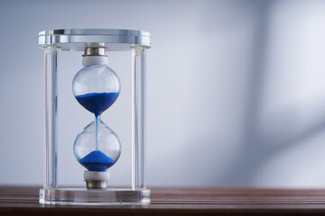 hourglass against gray backgroundwith window light