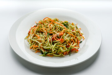 Fresh salad of sliced thin strips of carrot and zucchini on a concrete background