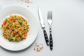 Fresh salad of sliced thin strips of carrot and zucchini on a concrete background
