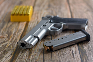 Semi automatic pistol, stainless steel with magazine and bullets selective focus.