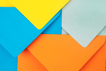 Orange, blue, yellow and silver envelopes forming a modern geometric pattern.