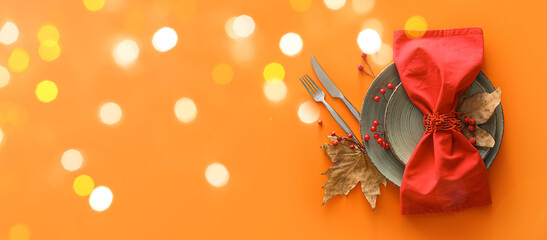 Beautiful autumn table setting on orange background with space for text