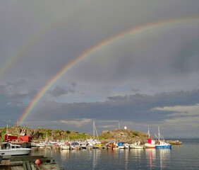 Naklejka na ściany i meble Regenbogen über kleinem Hafen in Norwegen 