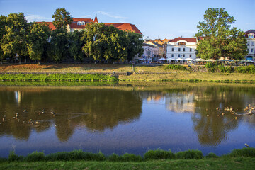 Fototapeta na wymiar Clear weather in a quiet town. River Uzh is in the foreground. Trip to Uzhgorod