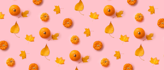 Many ripe pumpkins and autumn leaves on pink background. Pattern for design