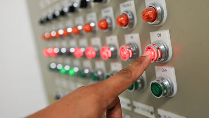 Close up human finger press button of control switch on DCB board