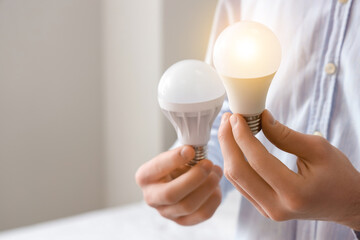 Man with light bulbs at home, closeup