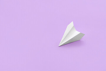 White paper plane on lilac background