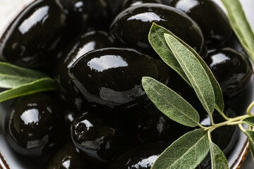 Bowl of tasty black olives, closeup