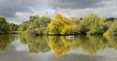  Autumn foliage reflected on a lake with a glass-like mirror water surface