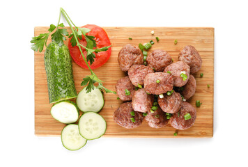 Wooden board with tasty meat balls and vegetables on white background