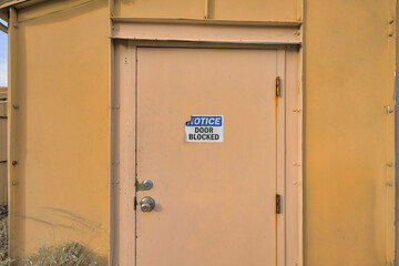 Tucson, Arizona- Notice Door Blocked signage on a cream colored door