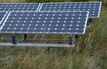 Konzept Sonnenenergie, Klima und Nachhaltigkeit: Kleine private Photovoltaikanlage im D&uuml;nengras