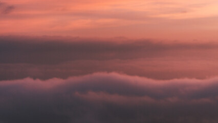 foggy sky during dusk - clouds and mist over mountains and beautiful orange sky