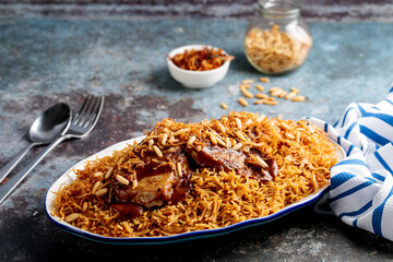 sayadieh or sayadiya topping with meat, fried onion and nuts served in a dish side view isolared on wooden table