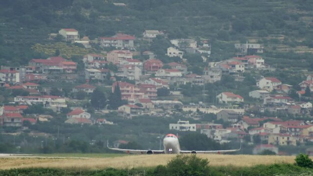An airplane takes off from an airport runway in a cityscape. Slow motion video of the plane taking off from the ground. High quality 4k footage