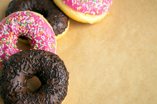 Delicious chocolate and strawberry glazed donuts with sprinkles background image