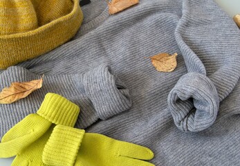 Autumn concept. Grey knitted sweater, yellow wool hat and yellow gloves. Top view.