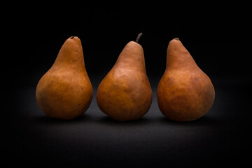 Three ripe pears on a black background