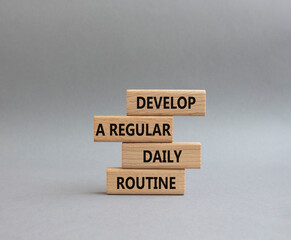 Develop a regular daily routine symbol. Concept words Develop a regular daily routine on wooden blocks. Beautiful grey background. Business and Develop a regular daily routine concept. Copy space.