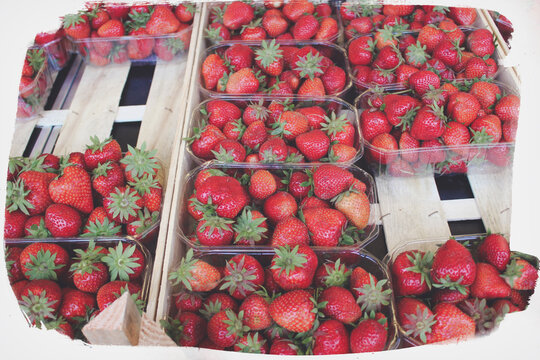 Closeup of fresh strawberries packed in plastic boxes, faded colors