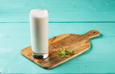 Ayran Laban or sweet lassi with milk and yogurt served in a glass isolated on cutting board side view healthy drink