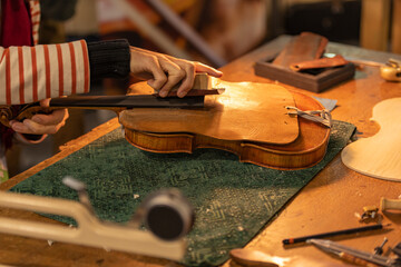 Close up of professional master artisan luthier working on creation of handmade violin in a...