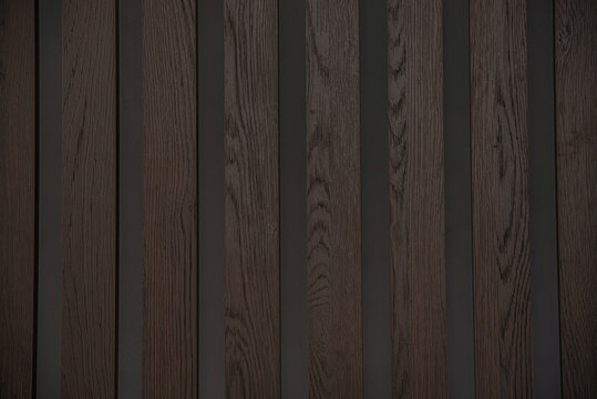 Dark background with stripes of wood panels. Wenge tree, abstract background.