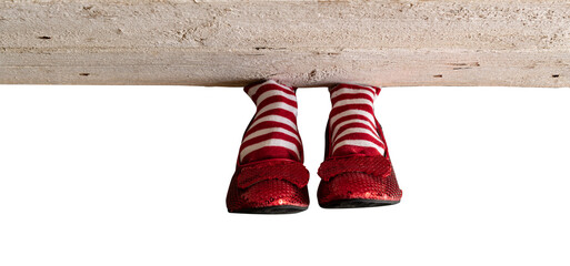 Red and white stripe socks with red ruby slippers isolated under a wood board - obrazy, fototapety, plakaty