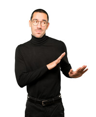 Naklejka premium Doubtful young man doing a gesture of keep calm