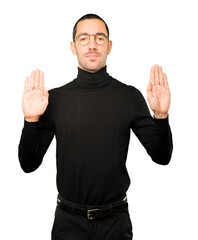Naklejka premium Happy young man making a gesture of stop with his palm