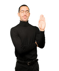 Serious young man making a gesture of stop with his palm