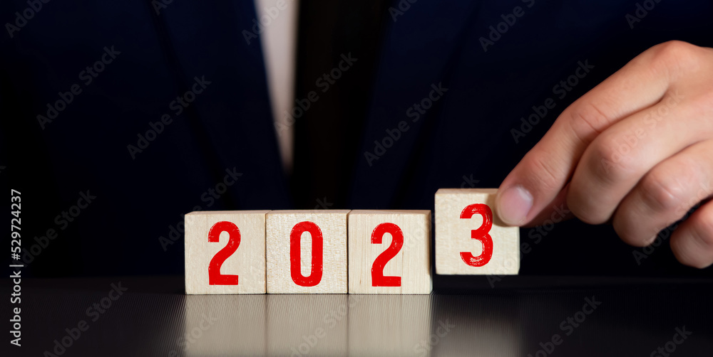 Poster 2023. wooden cube with flip over block 2022 to 2023 word.