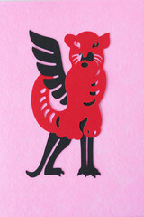 stylized tiger glyph and mythological creature meshed together and isolated on pink felt