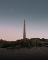 Lighthouse on the beach at dusk. 