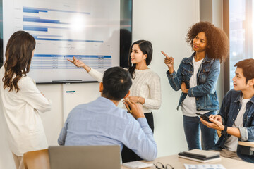 Fototapeta premium Young and successful mixed race, asian business people working on project together, sitting at table in boardroom.
