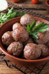 Tasty cooked meatballs with parsley on wooden table