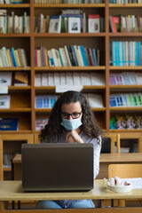 Young woman student study in the library using laptop