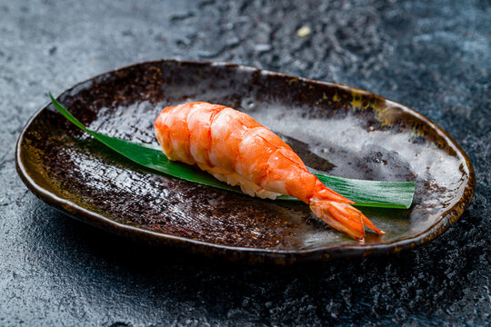 sushi with shrimp on dark stone table