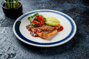 Salmon steak on the grill with mashed wasabi and sweet chili sauce