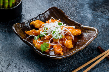 Shrimp in sweet sour sauce on dark stone table