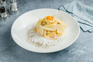 Spaghetti Carbonara with bacon and egg on grey table