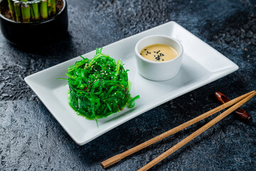 Chuka salad with peanut sauce on dark stone table