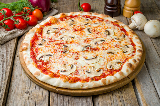 pizza with mushrooms, cheese and tomato sauce on wooden table close up