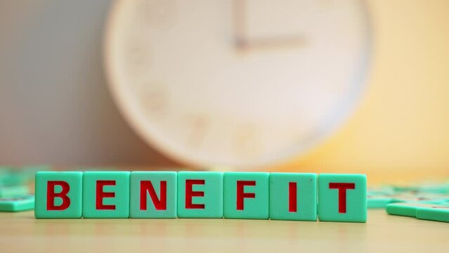 The word BENEFITS made of colorful scrabble tiles. . High quality 4k footage