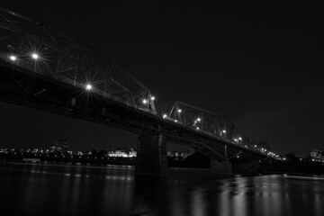 Fototapeta na wymiar Steel bridge over a river at night
