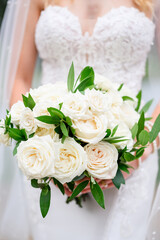 Beautiful woman in white dress holding bouquets 