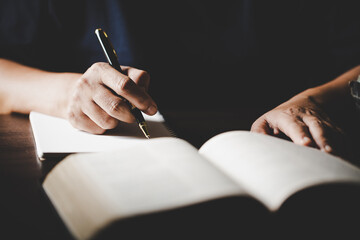 Young woman person hand holding holy bible with study at home. Adult female christian reading book...